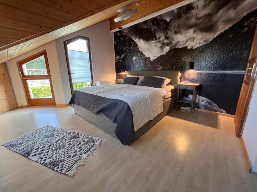 a bedroom with a bed and a large painting on the wall at sHÄUSL - Bergblick, TV, WLAN in Weitnau