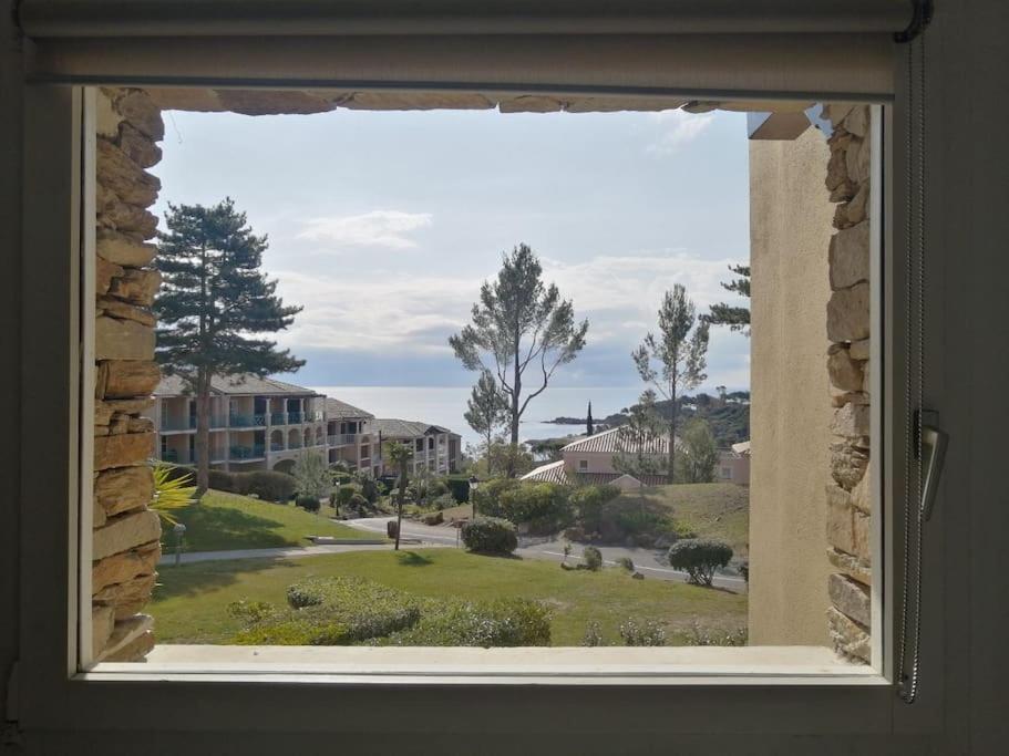 a window with a view of a yard at Complexe Cap Esterel village ,vue mer studio avec parking in Agay - Saint Raphael