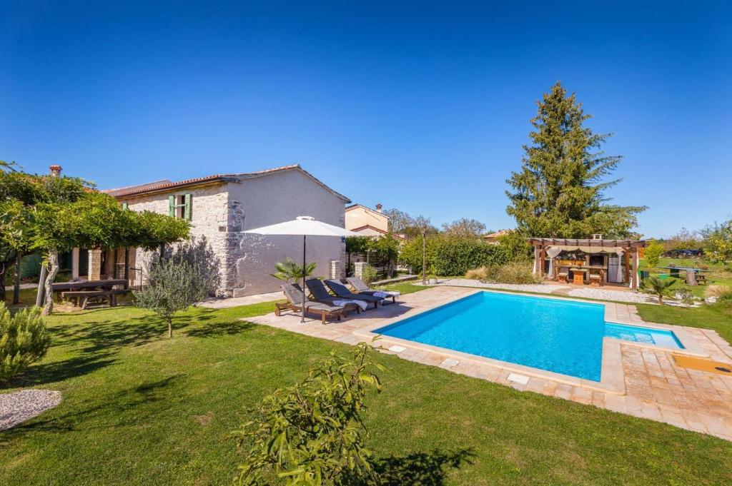 a backyard with a swimming pool and a house at Villa Stari Dor in Heki