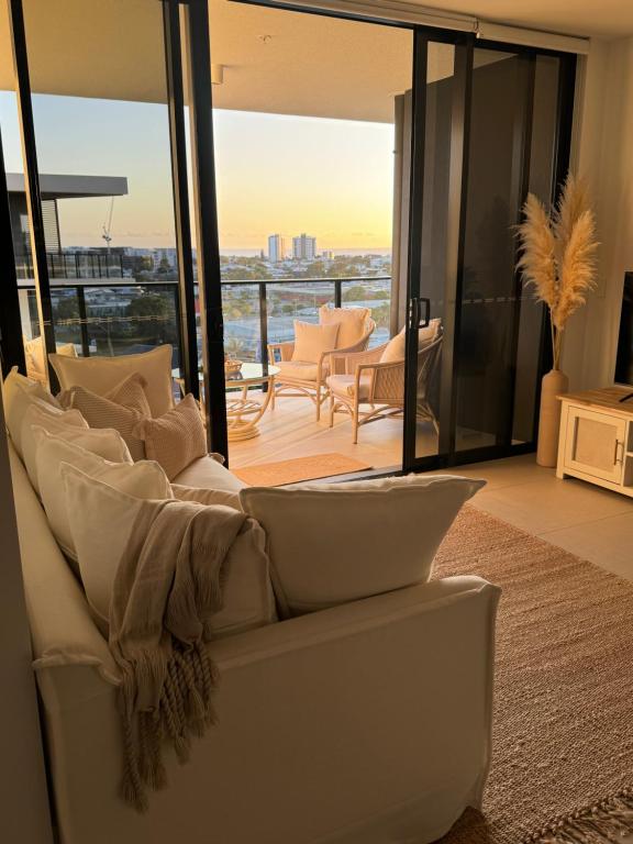 a white couch in a living room with a view at Sunshine Coast Paradise in Maroochydore
