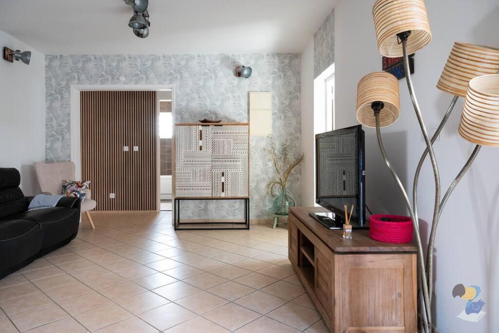 ein Wohnzimmer mit Couch und Fernseher in der Unterkunft La Case à Lila - DODOTERLA in Le Tampon