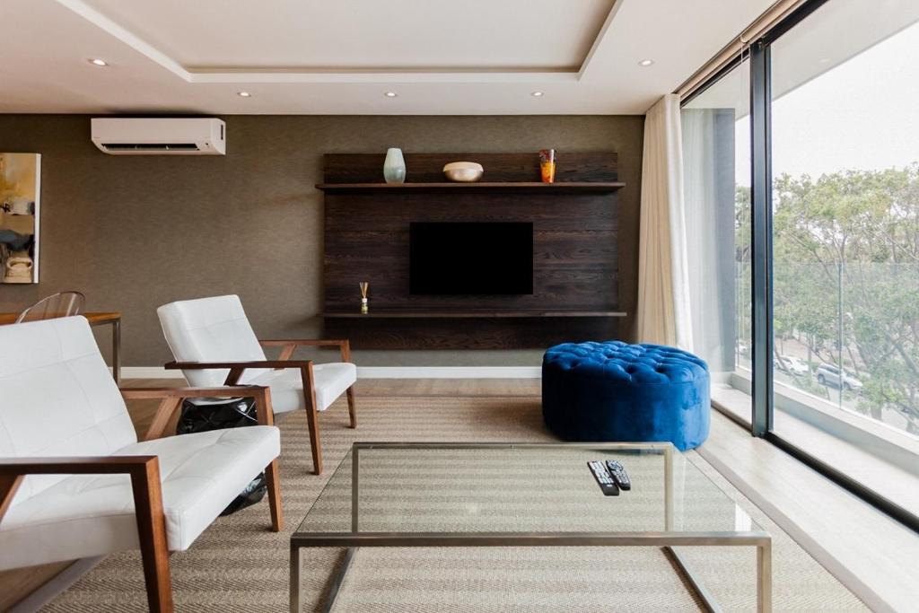 een woonkamer met een bank en een tv bij Warwick 30C in Kaapstad