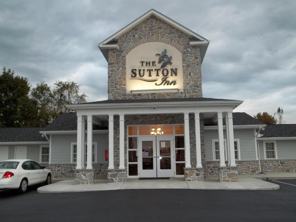 a building with a sign that reads the solution inn at Sutton Inn in Elkton