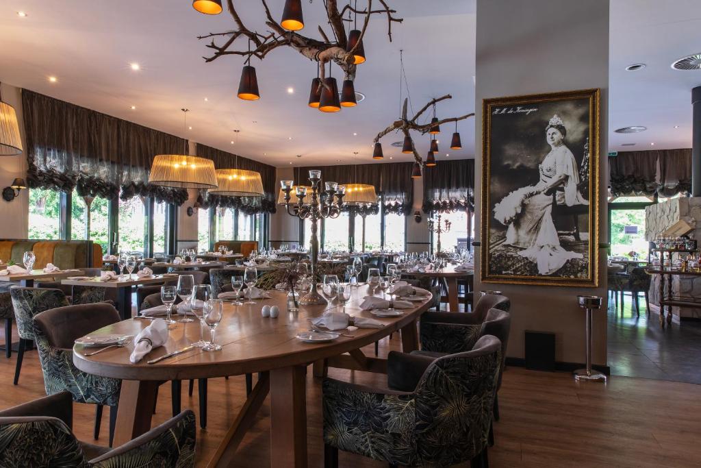 ein Restaurant mit Tischen und Stühlen und einem Bild an der Wand in der Unterkunft Schloss Basthorst in Crivitz