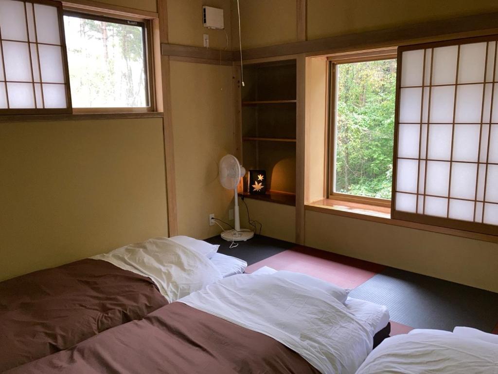 Postel nebo postele na pokoji v ubytování 安曇野市穂高温泉郷Vila湯仙望