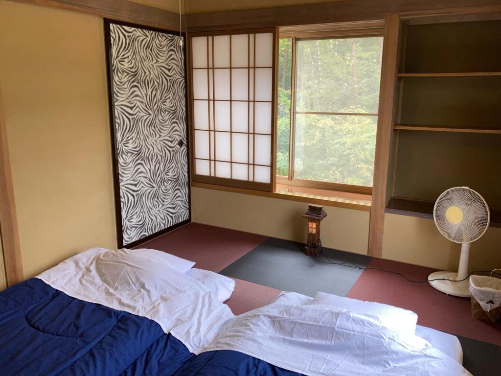 Postel nebo postele na pokoji v ubytování 安曇野市穂高温泉郷Vila湯仙望