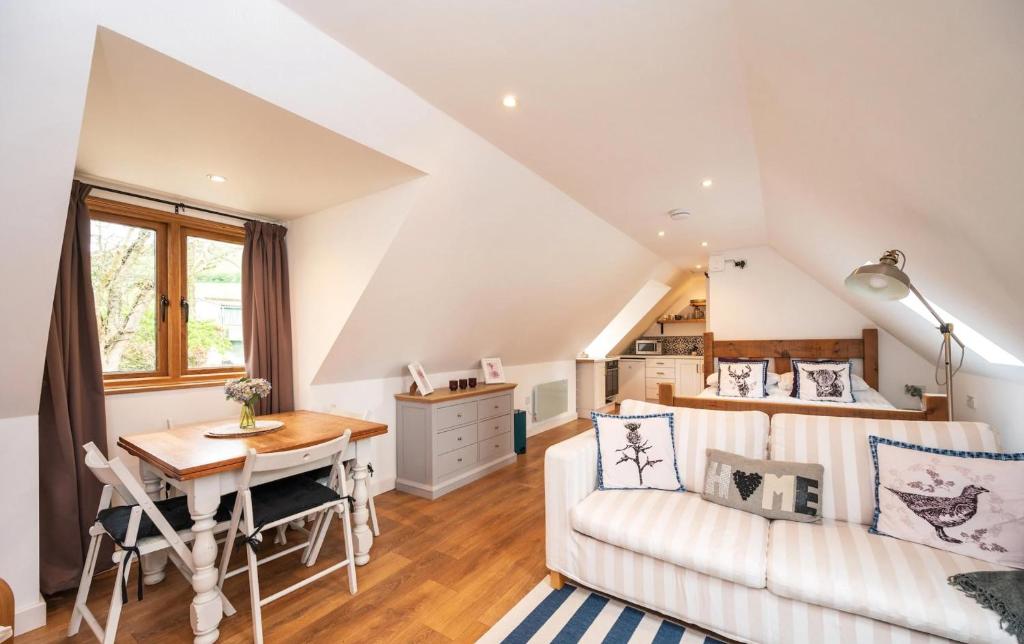 a living room with a couch and a table at Pentland Hills Chalet in Edinburgh