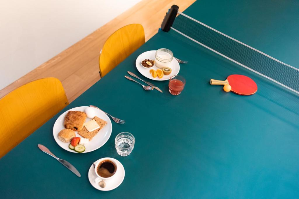 a table with plates of food and a cup of coffee at Conscious Hotel Vondelpark in Amsterdam