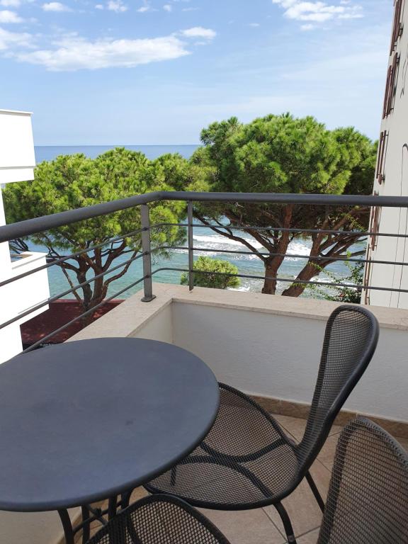 a table and chairs on a balcony with the ocean at Hotel Cala Luna in Cala Gonone