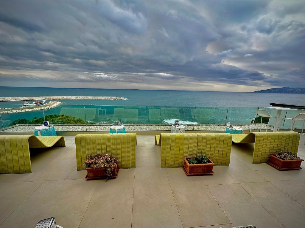 a balcony with yellow chairs and a view of the ocean at Hotel Cala Luna in Cala Gonone