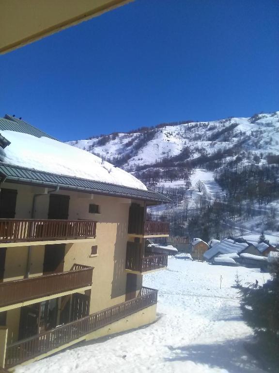 un bâtiment dans la neige avec une montagne en arrière-plan dans l'établissement Les Thymels, à Valloire