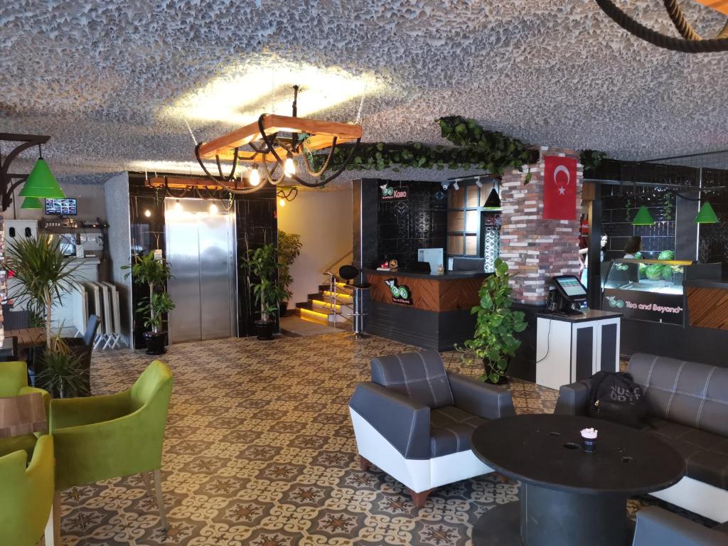 eine Lobby eines Restaurants mit einem Tisch und Stühlen in der Unterkunft Beyond OTEL in Antalya