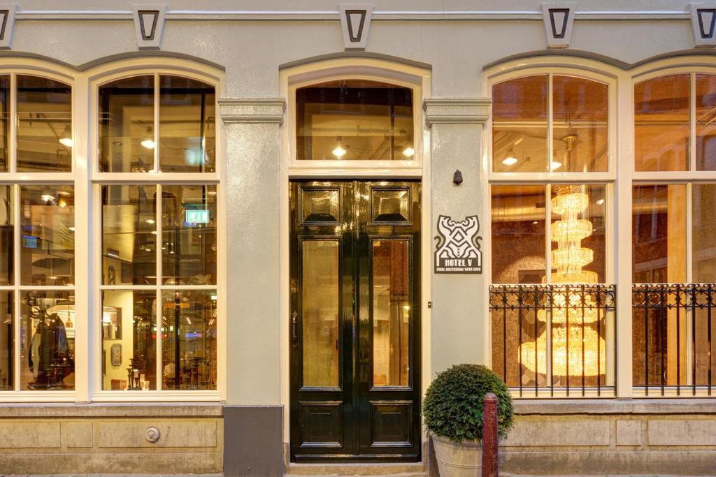 une façade de magasin avec portes et fenêtres noires dans l'établissement Hotel V Nesplein, à Amsterdam