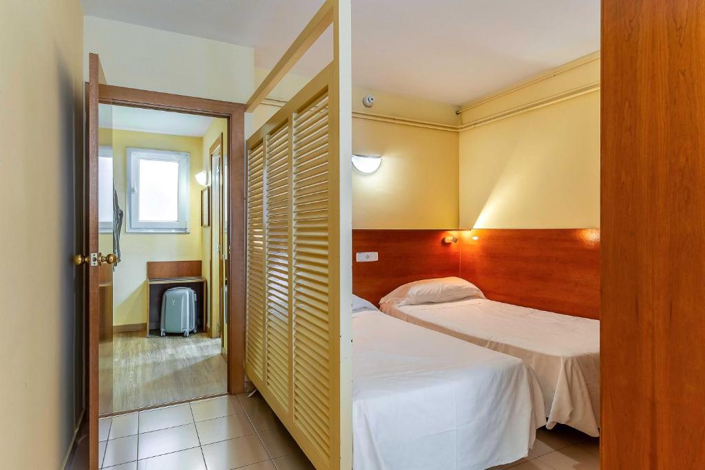 A bed or beds in a room at Aparthotel Bertrán