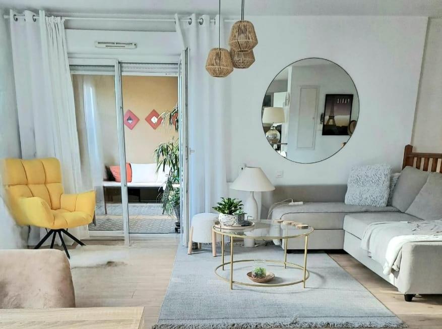 un salon avec un canapé et un miroir dans l'établissement Appartement cosy proche centre Arles, à Arles