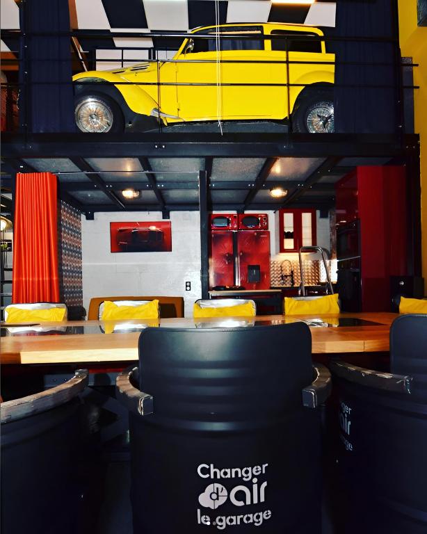une chambre avec une voiture jaune au-dessus d'une table dans l'établissement Le Garage - Changer d'air en Moselle, à Longeville-lès-Saint-Avold