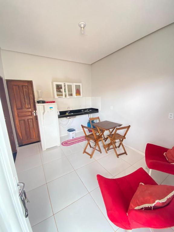 a living room with a table and a kitchen at Casa de dois quartos in Carolina