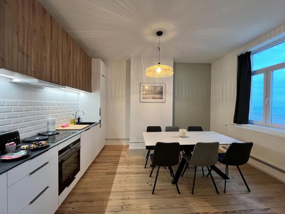 une cuisine et une salle à manger avec une table et des chaises dans l'établissement L'Oasis Vue Mer- MALO LES BAINS, à Dunkerque
