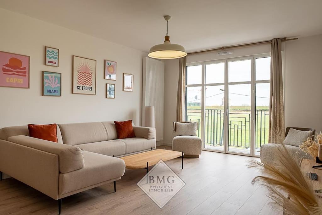 un salon avec un canapé et deux chaises dans l'établissement Rhapsodie Disneyland appartement, à Chessy