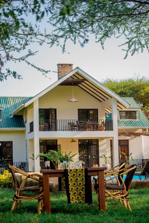 a house with a table and chairs in front of it at Amani Farmhouse in Usa River