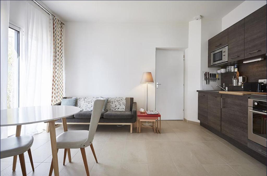 une cuisine et un salon avec une table et un canapé dans l'établissement Appartement T3 AU VIEUX PORT, à Saint-Quay-Portrieux