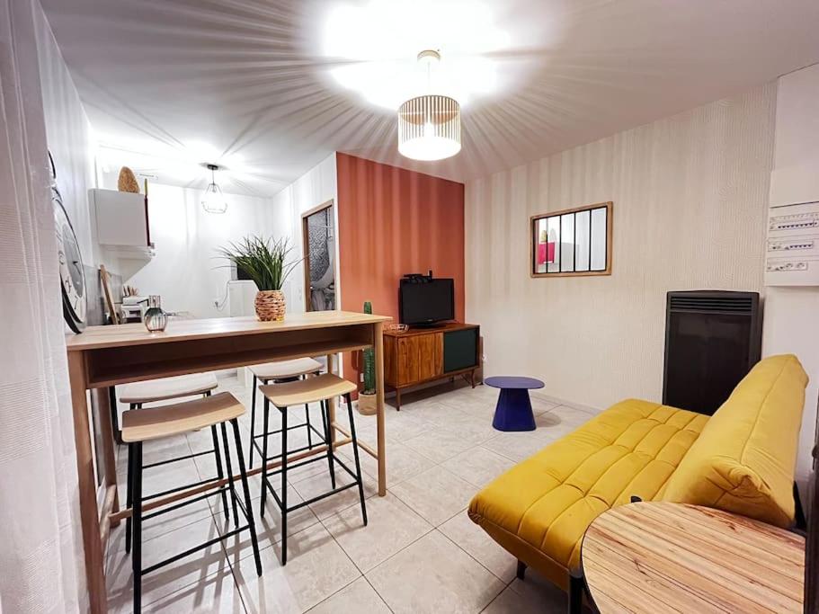 un salon avec un canapé jaune et une table dans l'établissement le zely, à Vézeronce