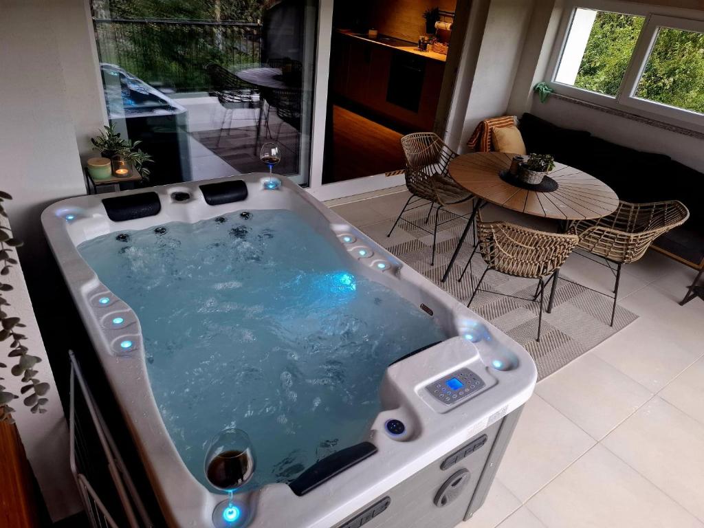 加蓬津Apartman Pojine的客厅配有热水浴缸和桌子
