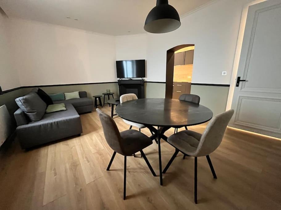 un salon avec une table, des chaises et un canapé dans l'établissement Emeraude vue mer MALO LES BAINS, à Dunkerque