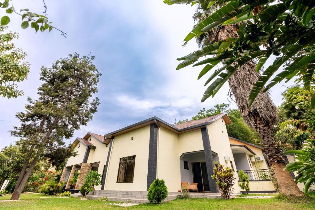 una casa con árboles delante en INTASHYA-Nest Villa, en Kigali
