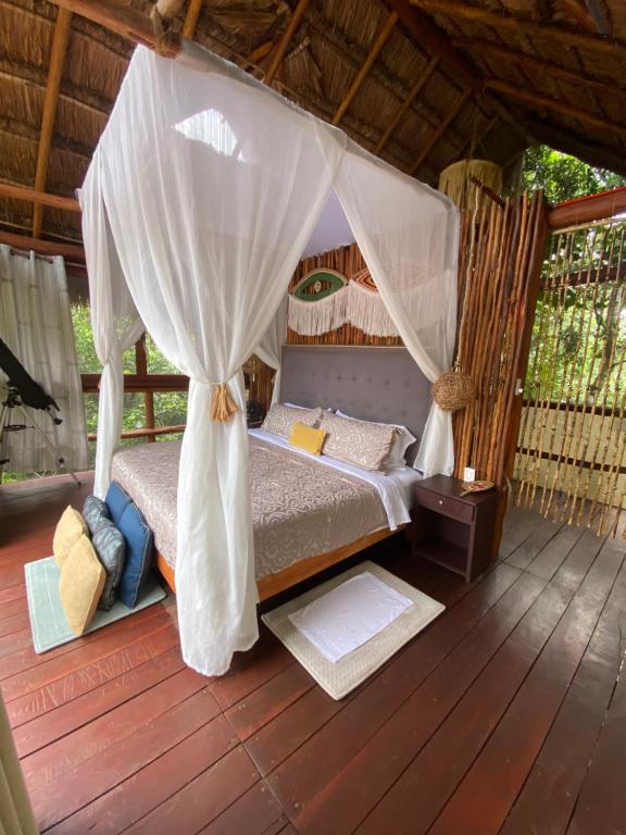 ein Schlafzimmer mit einem Himmelbett in der Unterkunft Evamayah in Leona Vicario