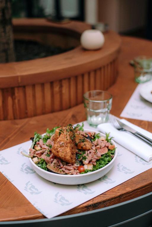 a plate of food on a table with a salad at Hotel Belleval in Paris