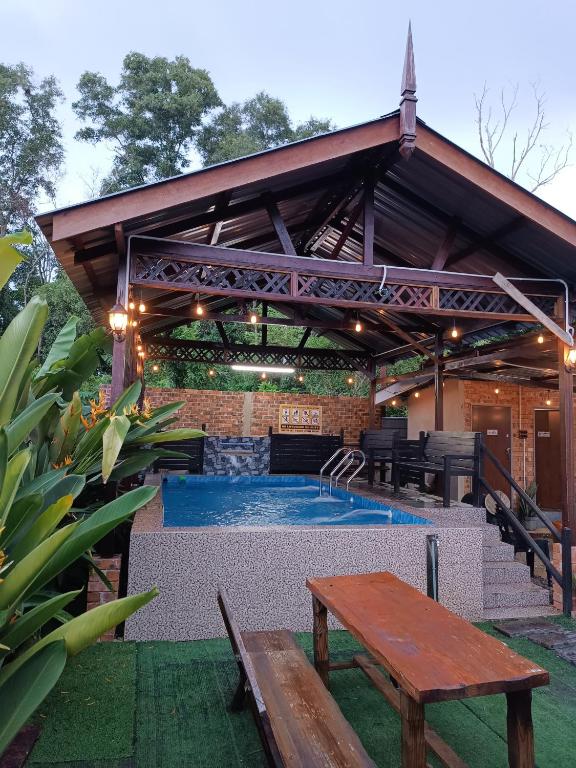 a pool with a pavilion with a table and a bench at De sepakat cottage private pool in Kuantan
