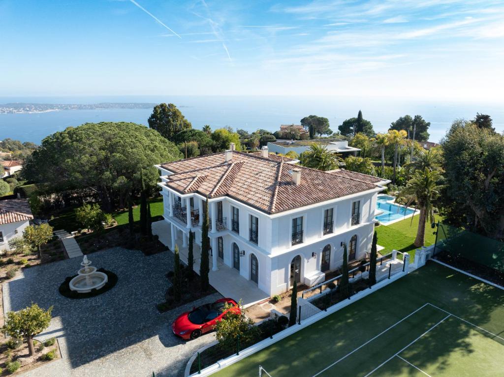 - une vue aérienne sur une maison blanche avec une piscine dans l'établissement Palace de Lys, à Cannes