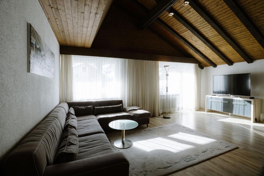 a living room with a couch and a table at Alpine Hotel Perren in Zermatt