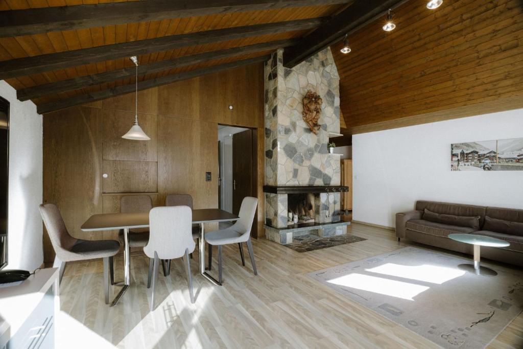 a living room with a table and chairs and a couch at Alpine Hotel Perren in Zermatt