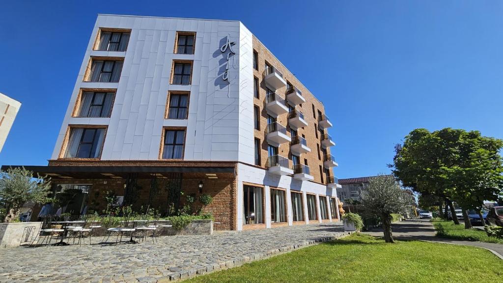 a building on a street with tables and chairs at Hotel Aria Suites in Târgovişte