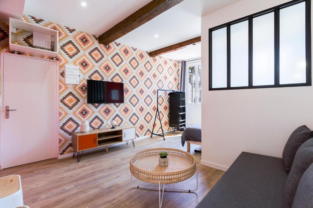 un salon avec un canapé et une télévision sur un mur dans l'établissement NATIONALE 4 - St Charles - Réformés - Vieux Port, à Marseille
