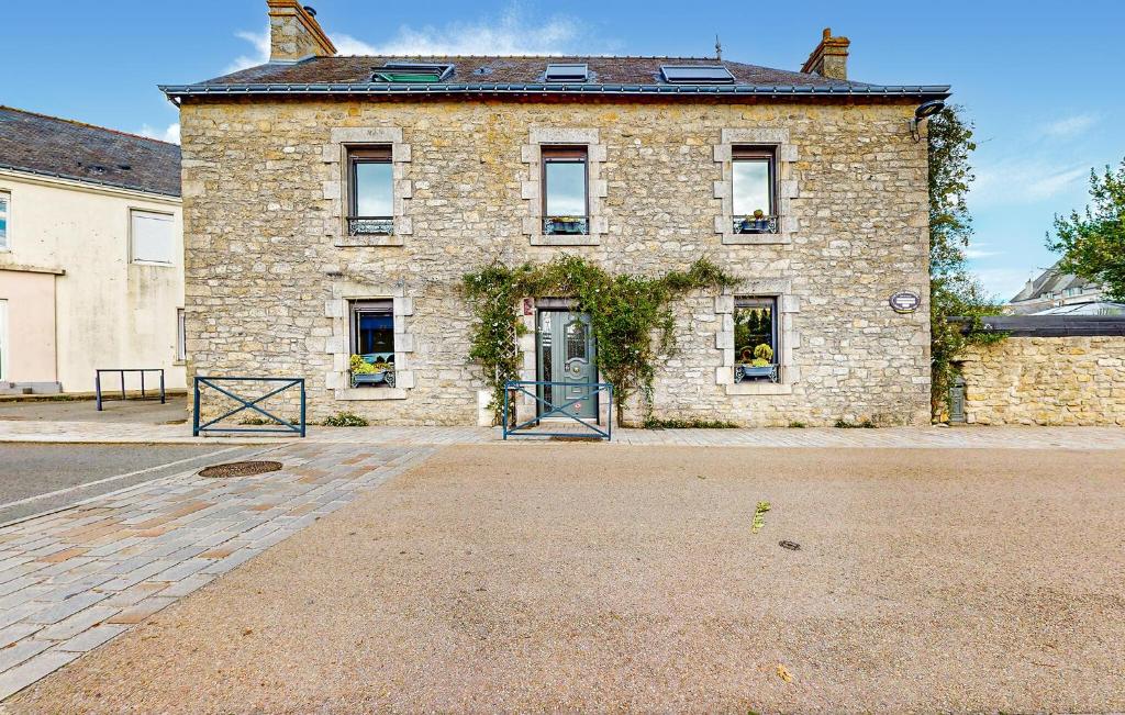 un vieux bâtiment en briques avec une porte dans une rue dans l'établissement Proche Mer, à Ploemeur