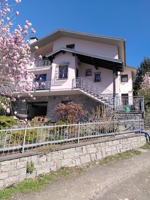 a white house with a fence in front of it at Casa Sala in Castionetto di Chiuro