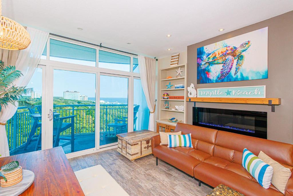 Una sala de estar con un sofá y una ventana grande. en Luxury 2BR With Custom Upgrades! The Horizon at 77th- 503, en Myrtle Beach