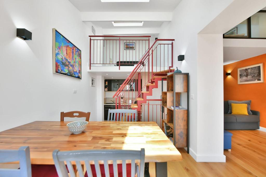 une salle à manger avec une table et des chaises et un escalier dans l'établissement LE CHARMANT sublime Maison de Ville dans le Suquet au calme, à Cannes