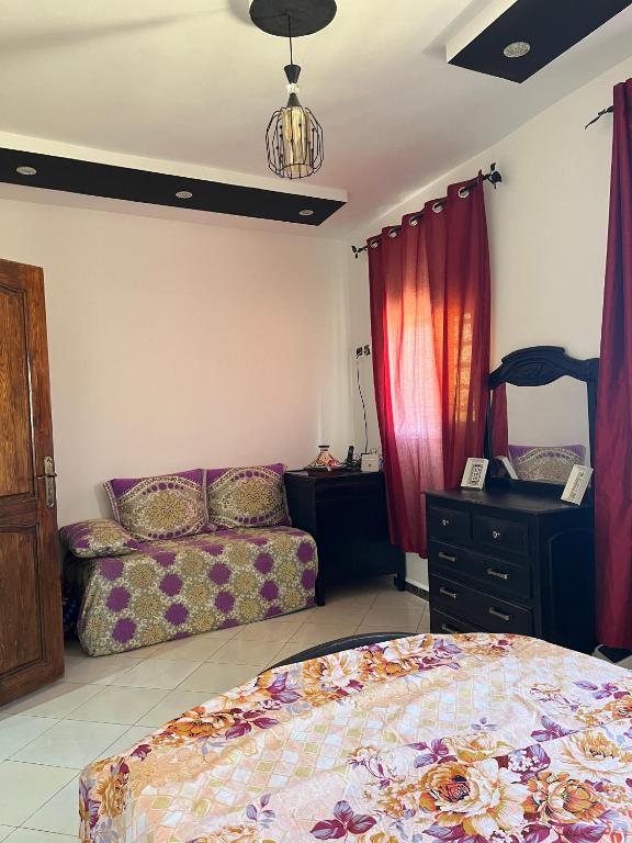a bedroom with a bed and a couch and a dresser at Modern Moroccan apartment near the beach in Safi in Safi