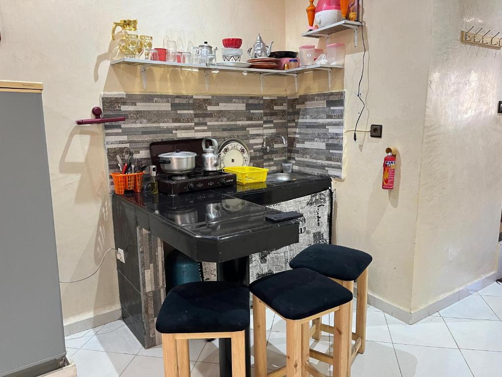 a kitchen with a stove and two stools at Modern Moroccan apartment near the beach in Safi in Safi
