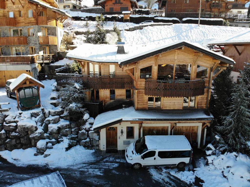 a car parked in front of a house with snow at Chalet Narnia in Morzine