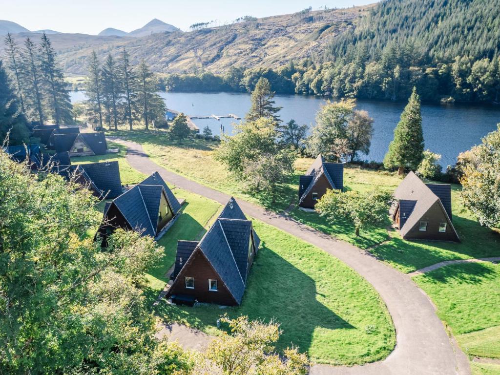an aerial view of a group of lodges with a lake at Chalet Caledonia Lodge by Interhome in Spean Bridge