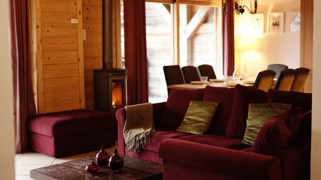 a living room with a red couch and a table at Chalet Tara in Morzine