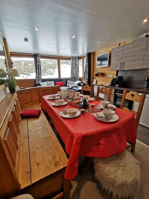 une salle à manger avec une table rouge dans un bateau dans l'établissement Sérac A5B5, à Val Thorens