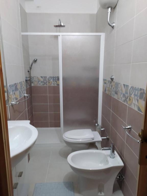Un baño con dos inodoros y una ducha. en B&b Continentale, en Scalea