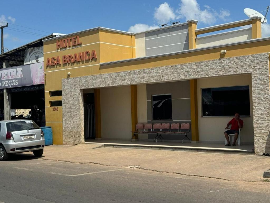 a man sitting in the window of a restaurant at Hotel Asa Branca in Boa Vista