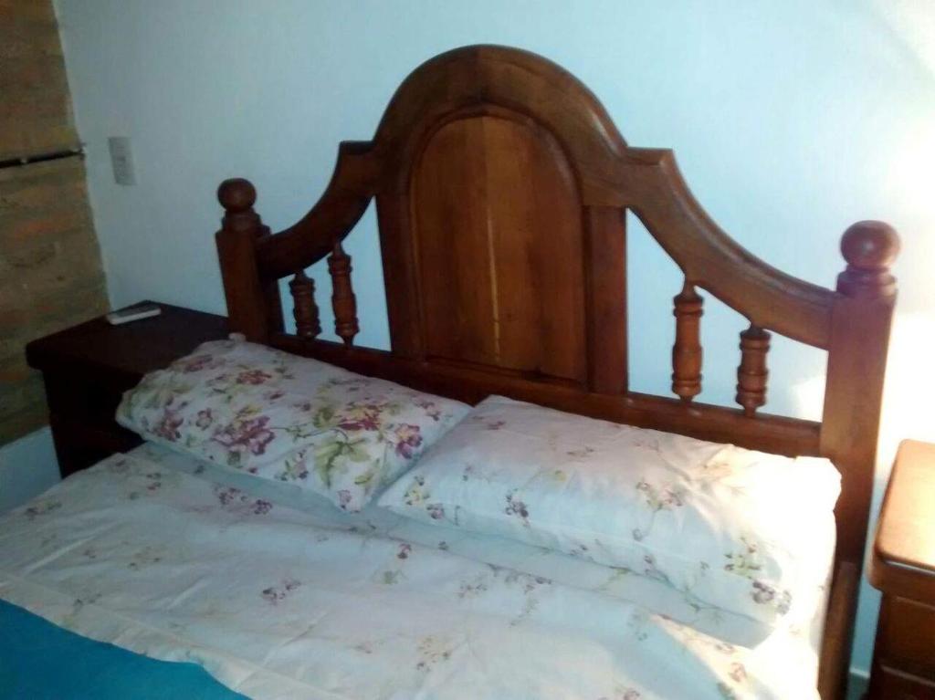 a bed with a wooden headboard and a pillow at DEPARTAMENtO LOFT in Posadas